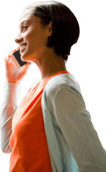 Femme souriante en haut orange, téléphone à l’oreille.